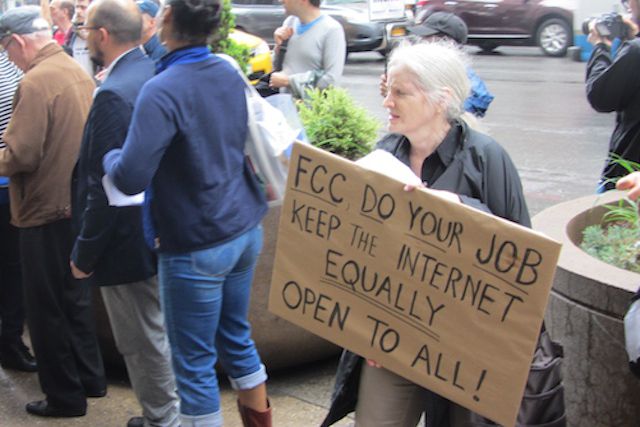A protester outside the FCC building today.